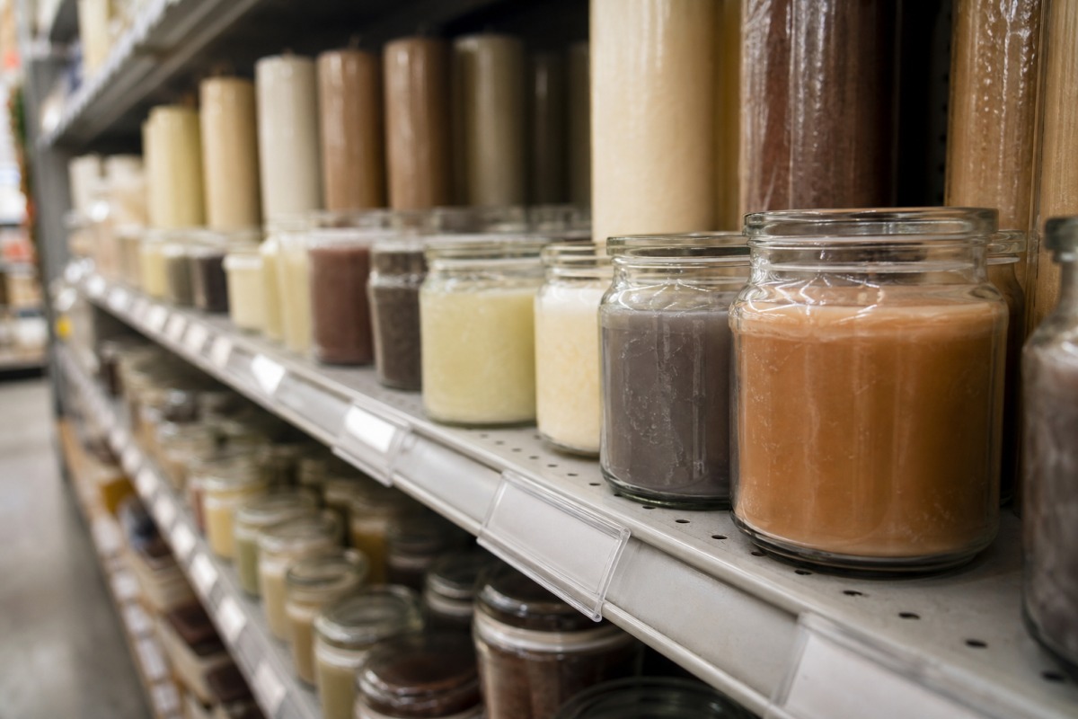 Hilera de velas baratas en vasos sencillos en un estante de droguería