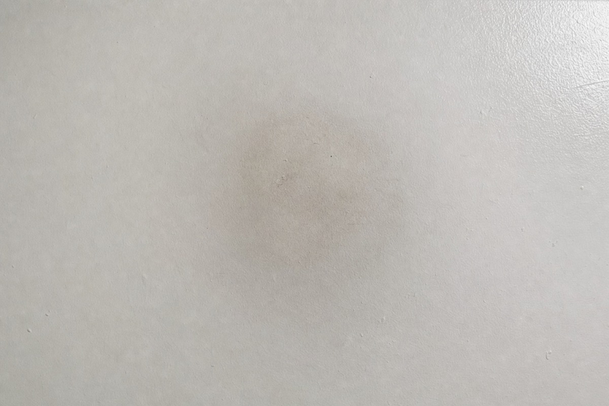 Una leve sombra gris de hollín en un techo blanco, sobre el lugar donde estuvo una vela de parafina
